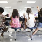 Students sit at a lunch table.