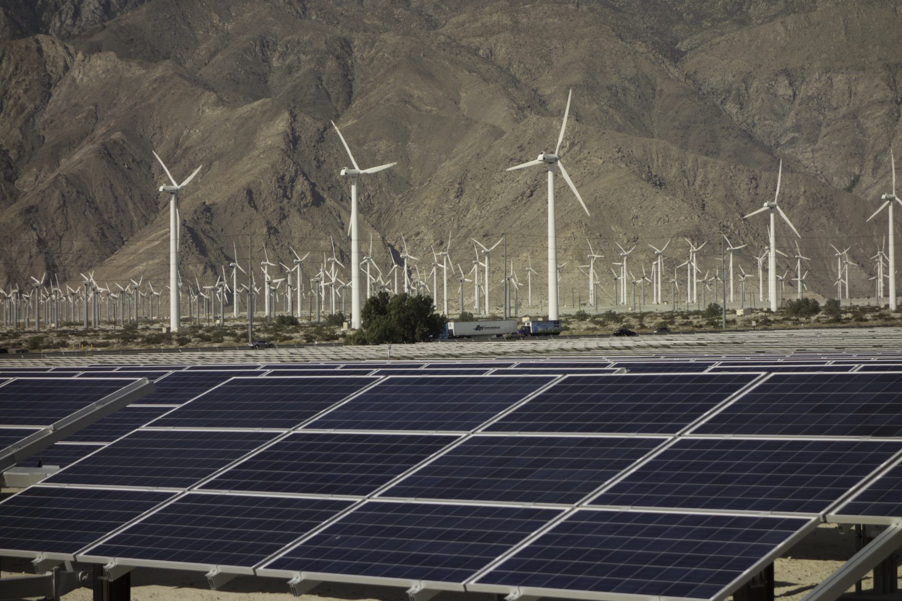 Solar panels and windmills in a desert.