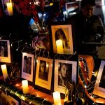 A community group holds a memorial vigil on Transgender Day of Remembrance. Pictures of the victims are displayed on a candlelit alter with their names and ages.