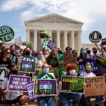 Members of Generation Ratify hold signs that read 