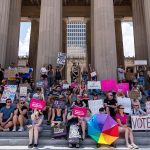 Abortion rights demonstrators sit on the steps of the Tennessee State Capitol while protesting.