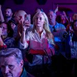 A woman takes a picture with her cellphone during a campaign event for GOP candidates at a restaurant.