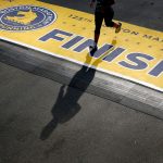 A runner casts a shadow as they cross the finish line of the 125th Boston Marathon.