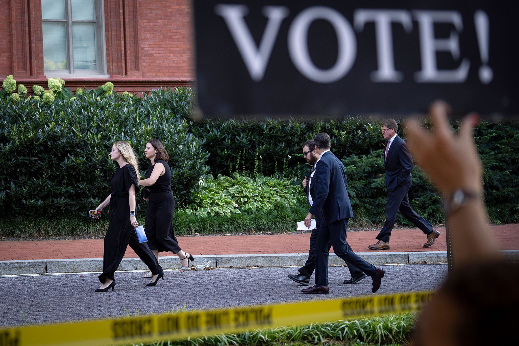 Abortion rights activists protest as guests arrive for the Susan B. Anthony Pro-Life America's annual gala. A large sign in the foreground reads "Vote!"