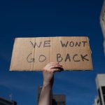 An abortion rights demonstrator raises a sign that reads 