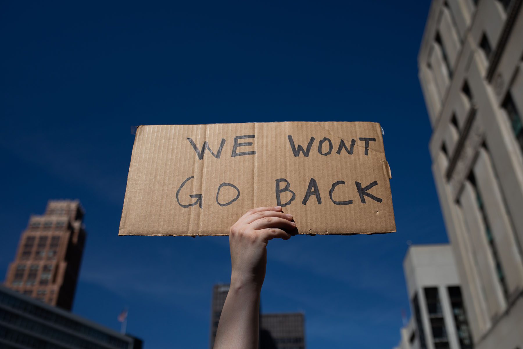 An abortion rights demonstrator raises a sign that reads "we won't go back."