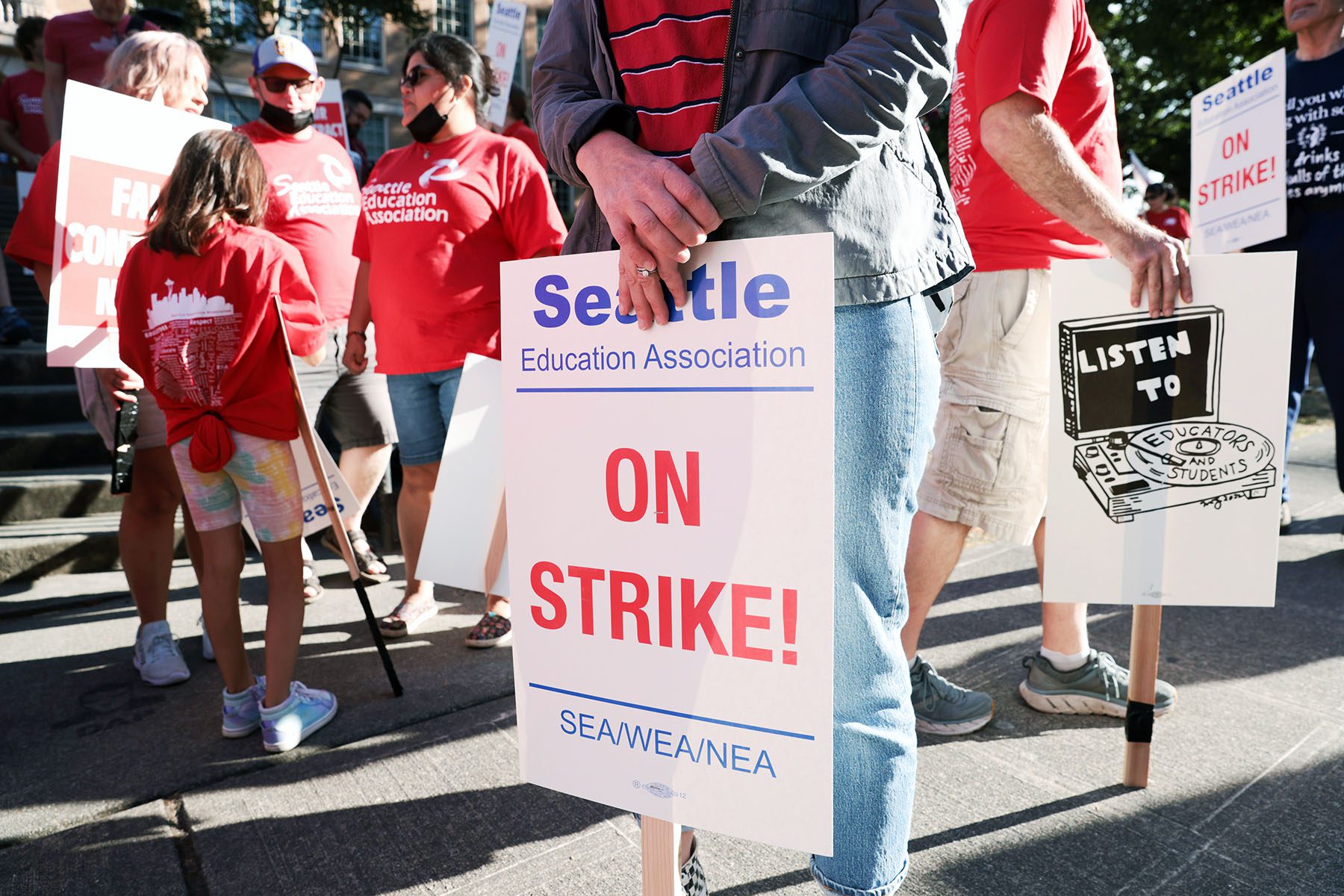 Teachers from Seattle Public Schools picket outside Roosevelt High School. A sign reads "seattle education associaction ON STRIKE!"