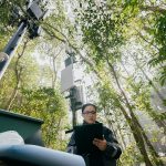 Asian female engineer debugging a 5G signal base station.