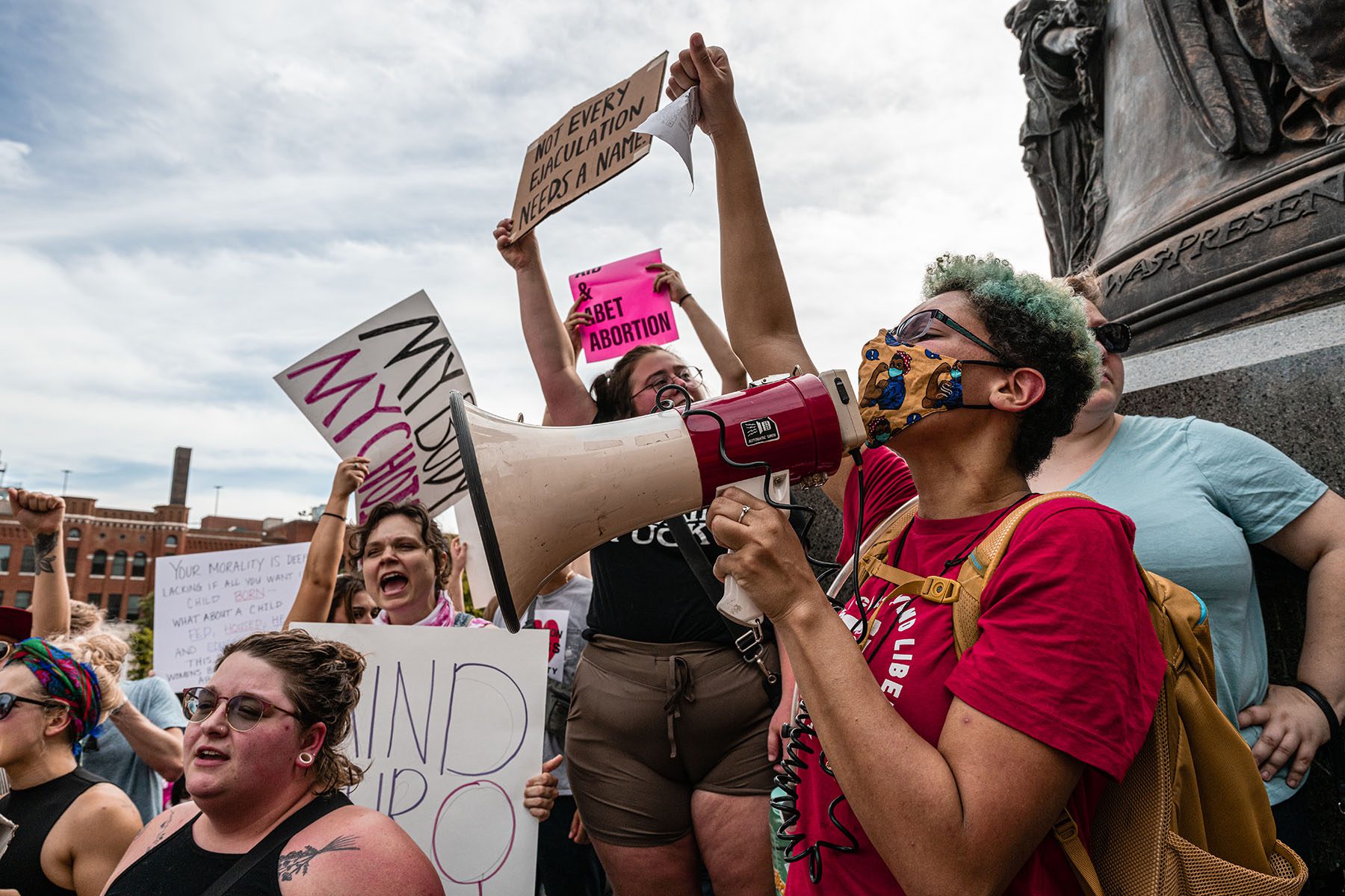 Abortion rights protesters chant and display signs at a demonstration.