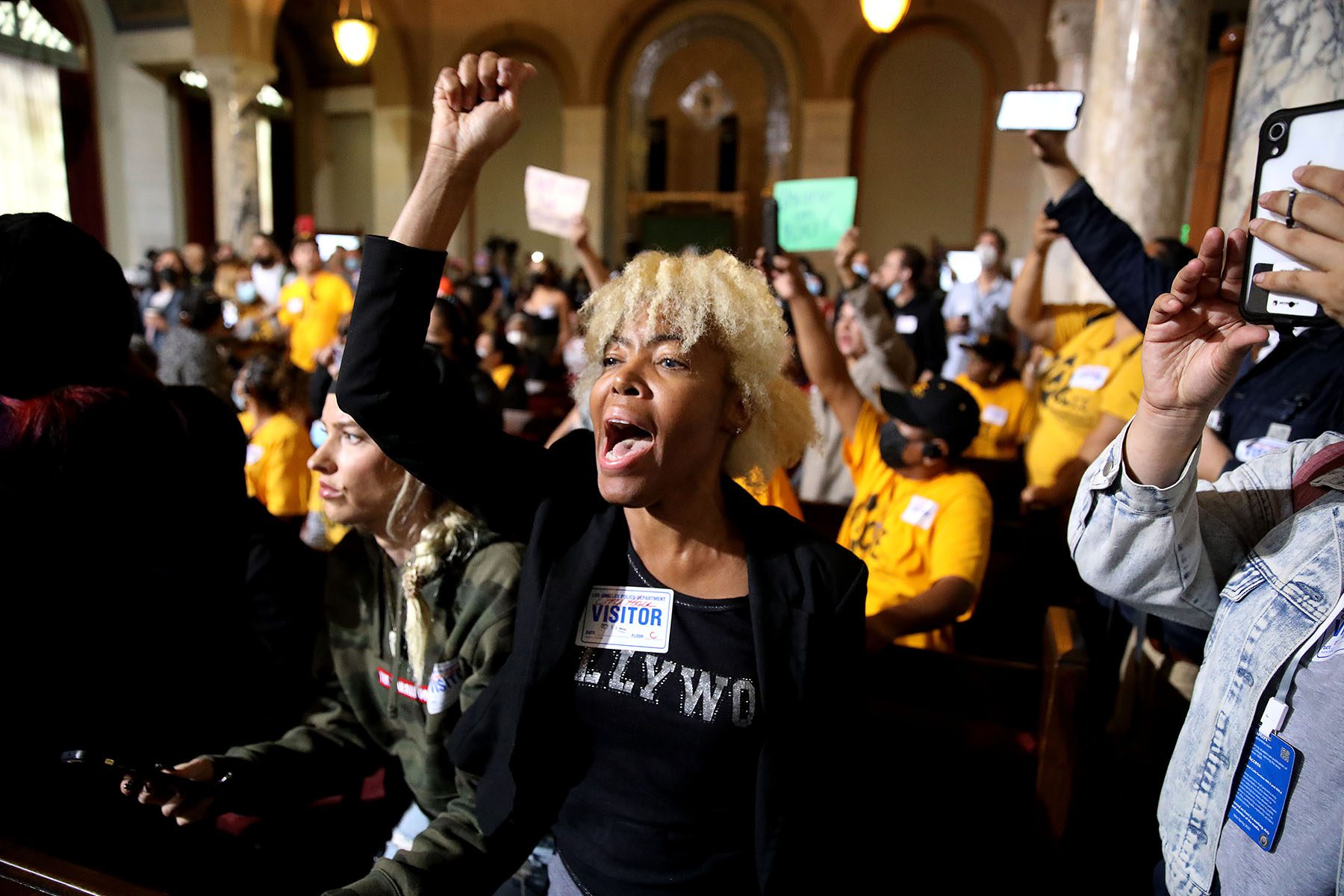 Protestors raise their fists and chant at the Los Angeles City council meeting.