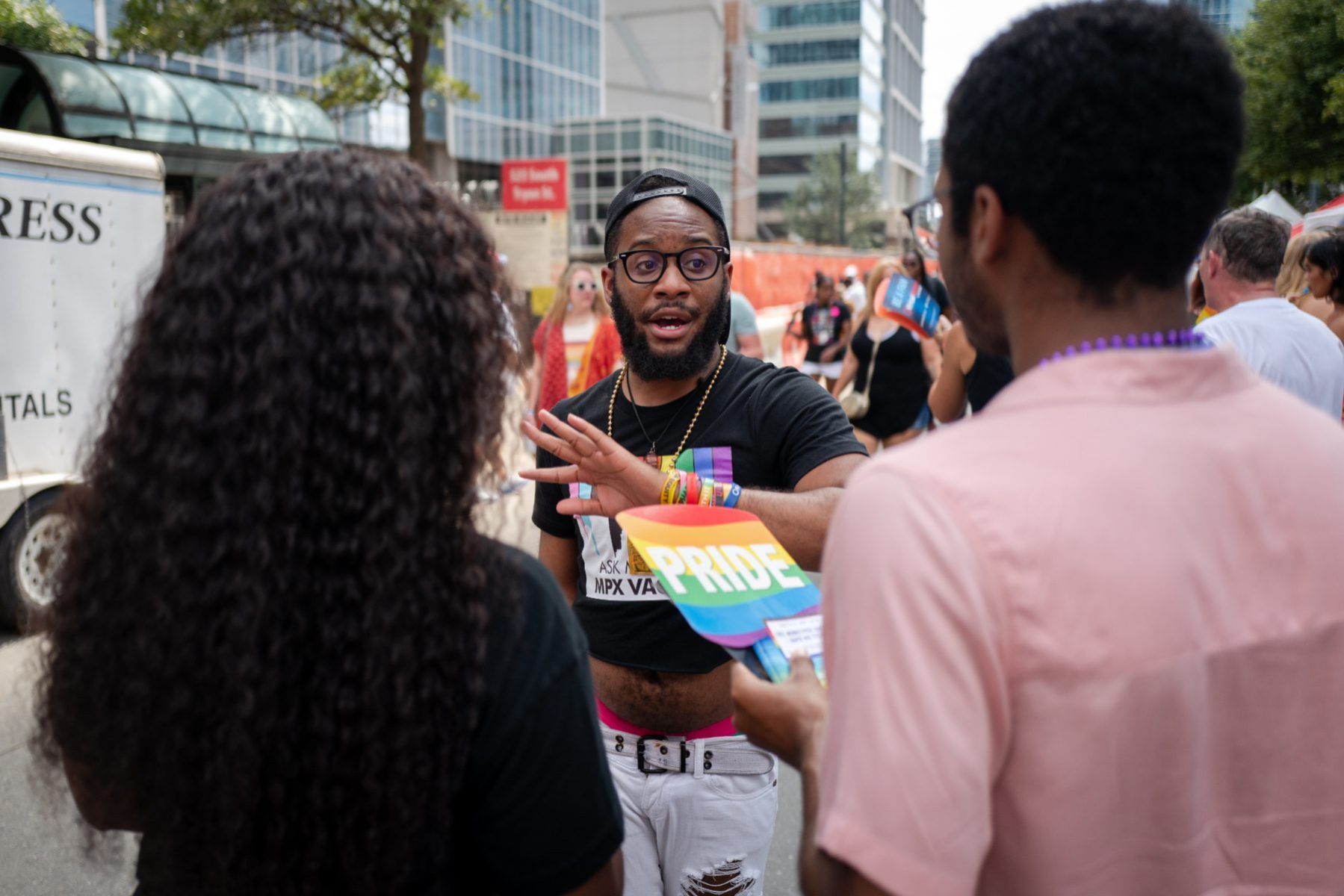 Johnny Wilson, an employee at the Mecklenburg County Health Department wearing a black shirt with a vaccine message, speaks with an individual about the Monkeypox vaccine at the 2022 Charlotte Pride Festival in uptown Charlotte, North Carolina on August 20, 2022.