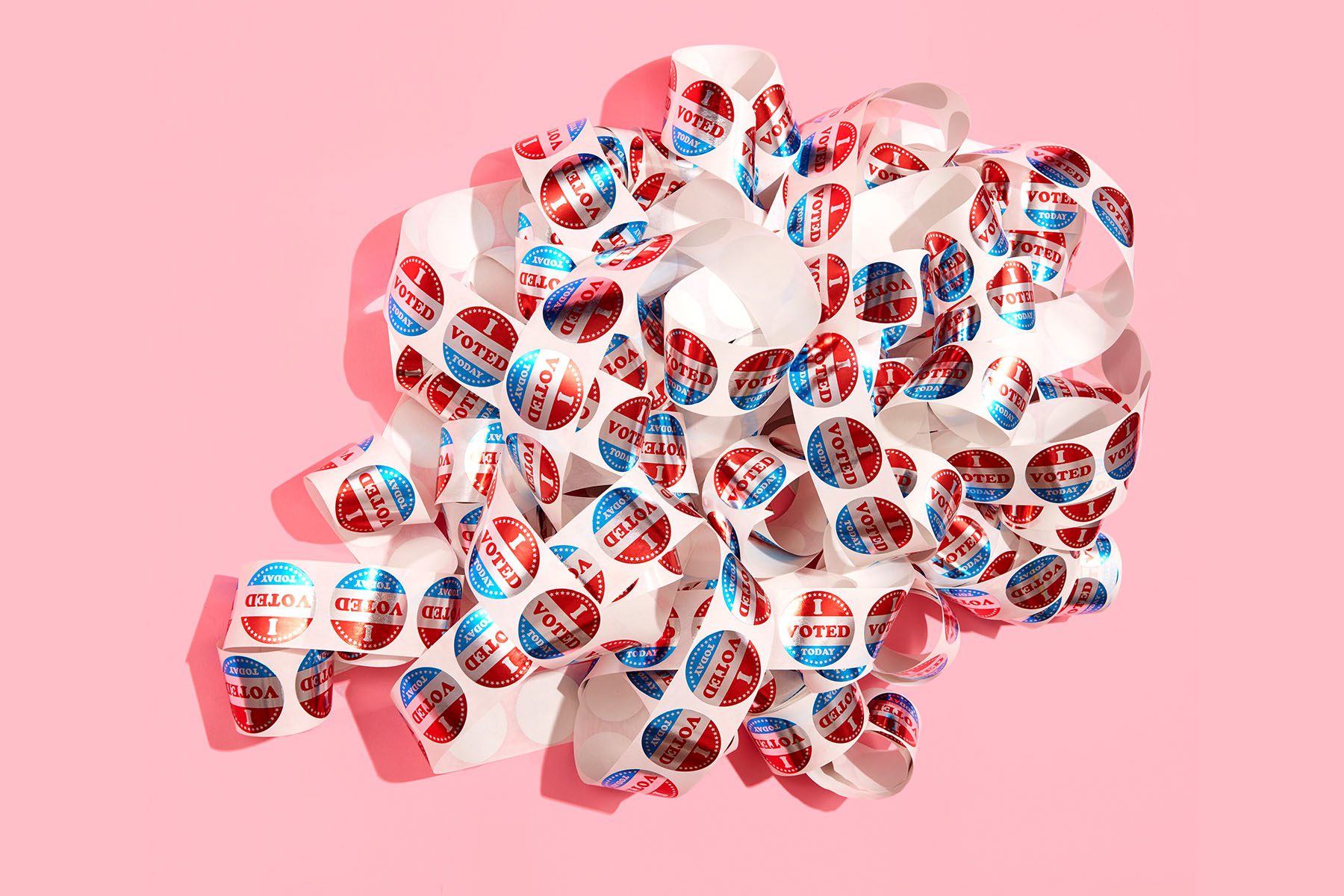 An unraveled and tangled sheet of "I voted" stickers .