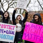 Harvard University freshmen carry signs that read 