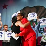 Karen Bass hugs her daughter as supporters holding 