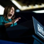 Sarah Huckabee Sanders speaks at a podium during the America First Agenda Summit.