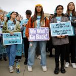 Proponents for affirmative action in higher education hold signs that read 