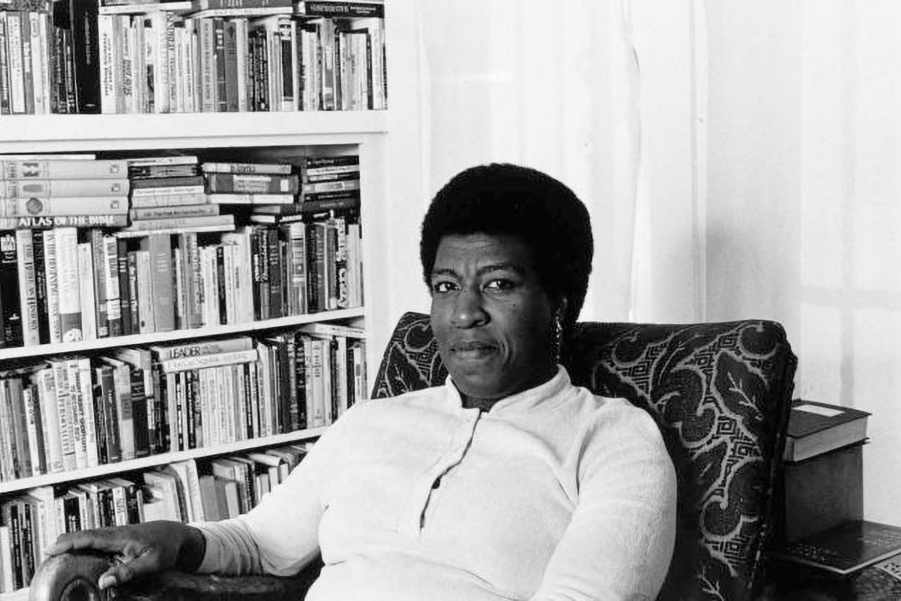 Octavia Butler poses for a portrait near her bookcase.