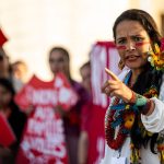 An Indigenous woman speaks during a demonstration calling attention to stolen land.