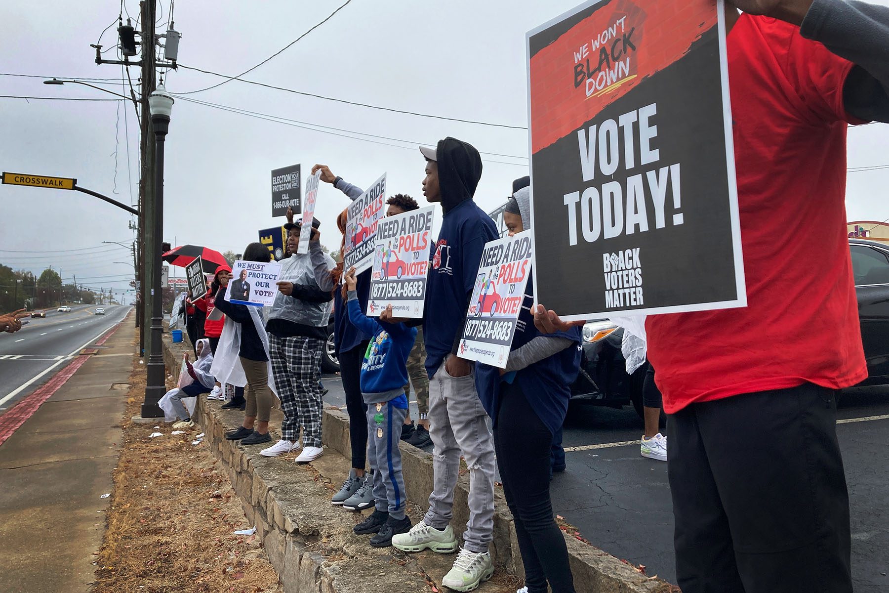 Young activists hold signs that promote free rides to the polls.