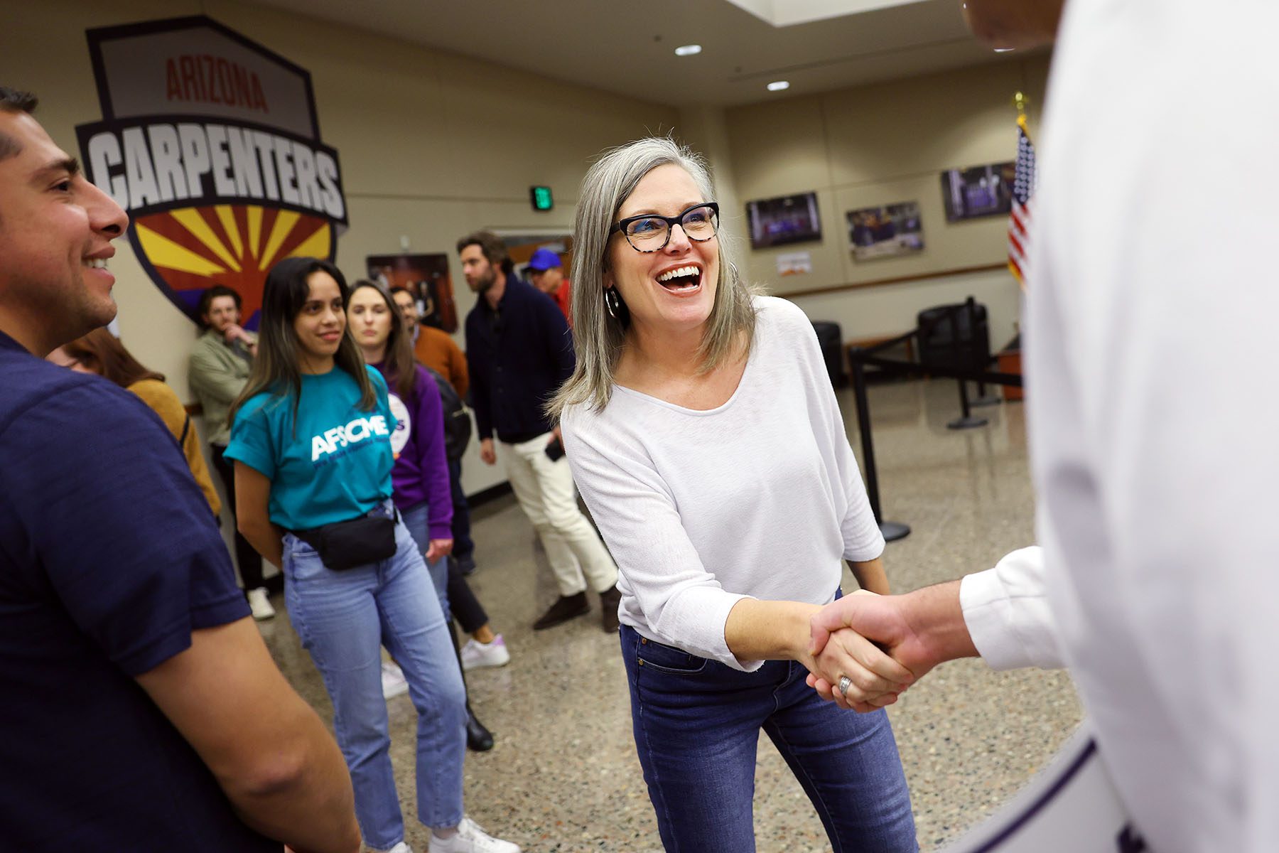 Katie Hobbs smiles while shaking a supporter's hand at the Carpenters Local Union 1912 headquarters.