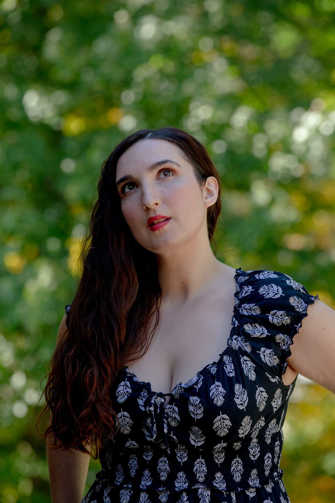 Portrait of Sarah Anne Masse looking up at some trees in afternoon light.