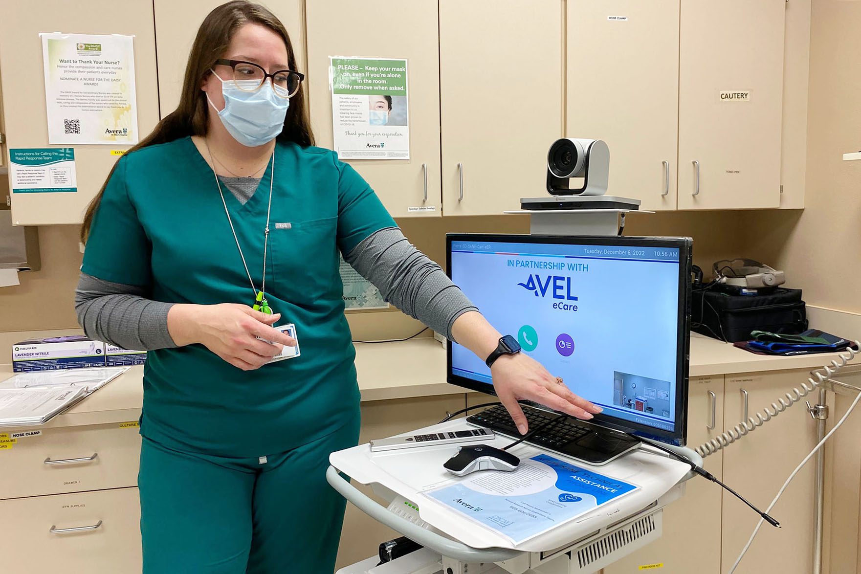 Nurse Lindee Miller stands in front of the mobile cart used for telehealth appointments for sexual assault exams.