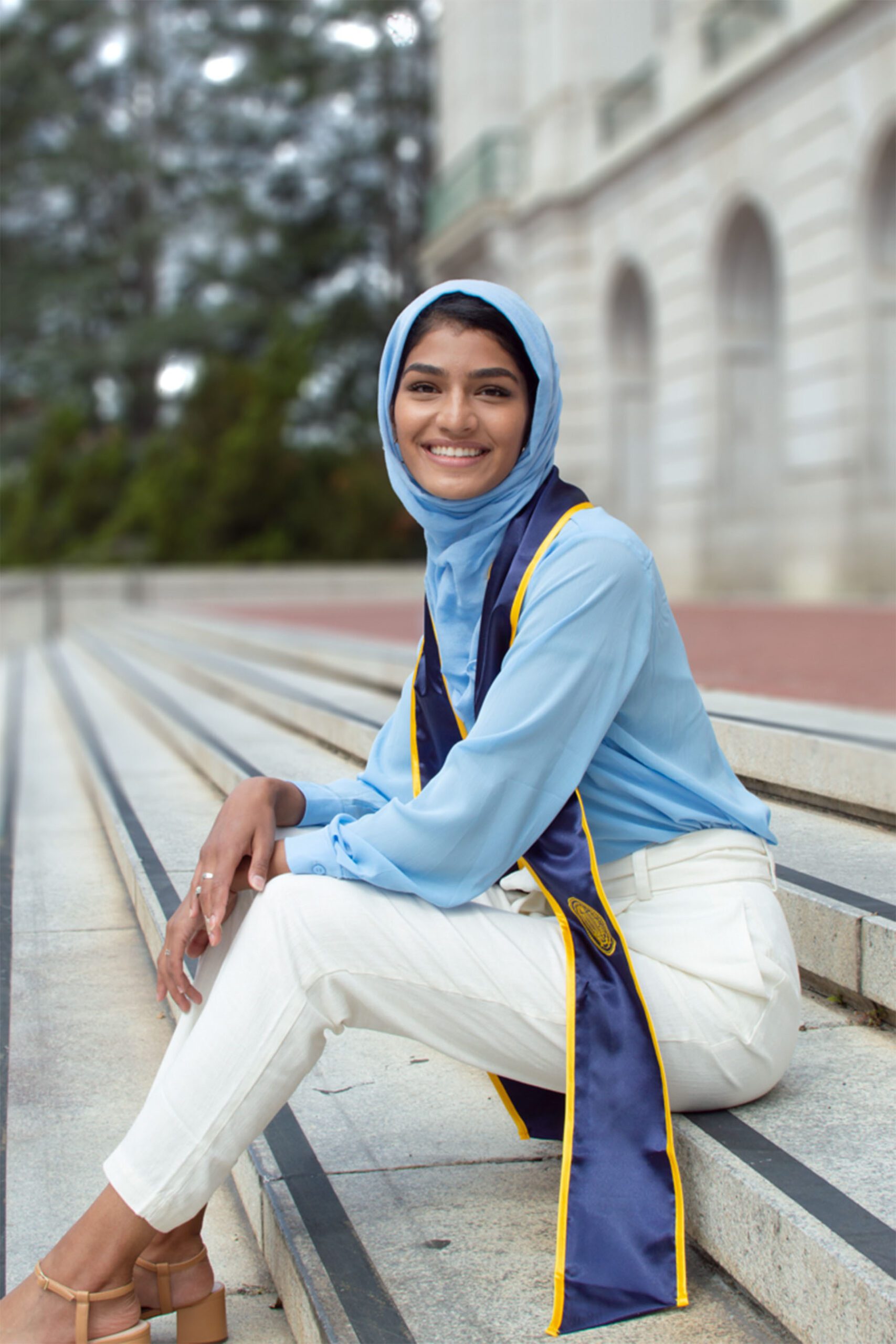 Nabeela Syed sits on the steps of the Doe Memorial Library at the University of California, Berkeley.