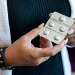 A woman holds a pack of pills holds up pills used for abortions.