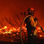 A firefighter monitors the Dixie Fire.