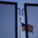 american flag as seen through a security fence at the Supreme Court in Washington DC