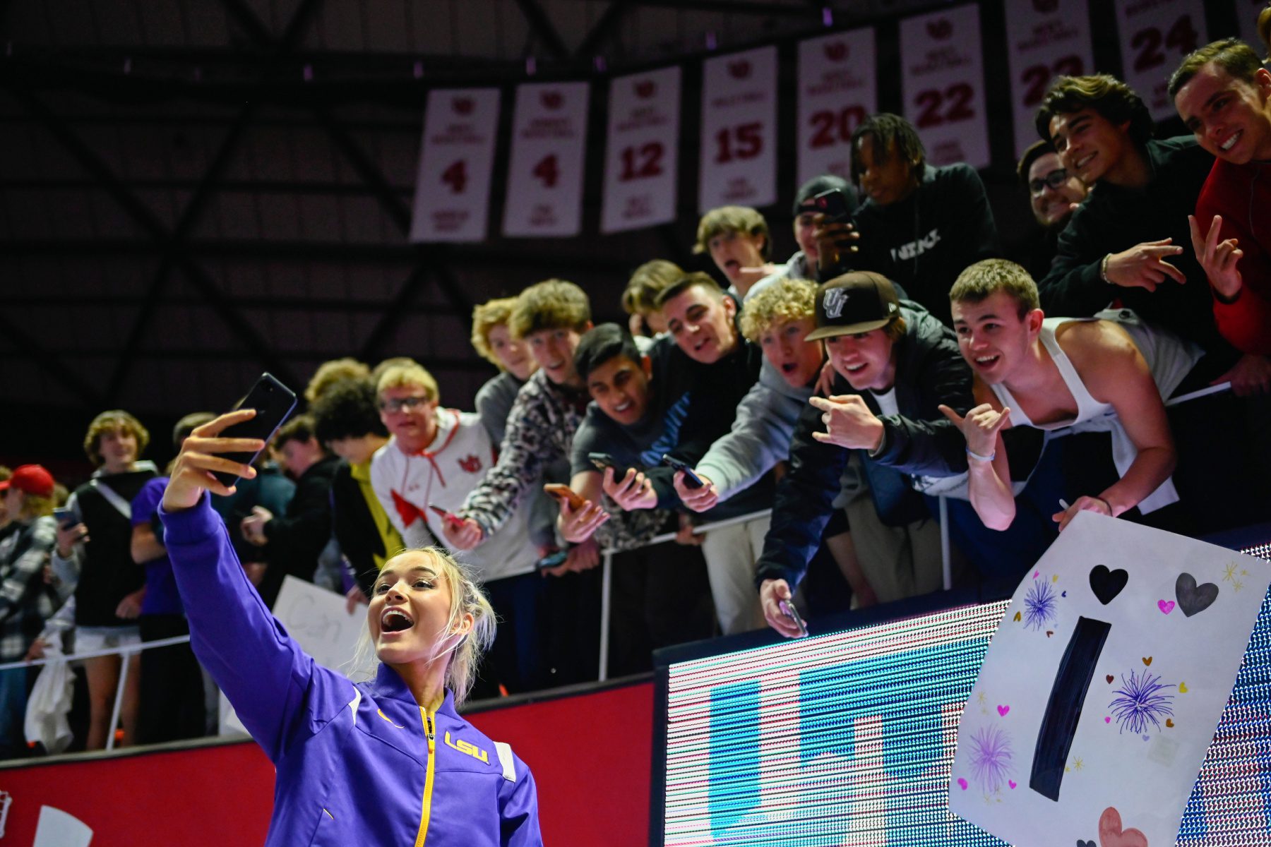 Olivia Dunne takes a selfie with male fans.