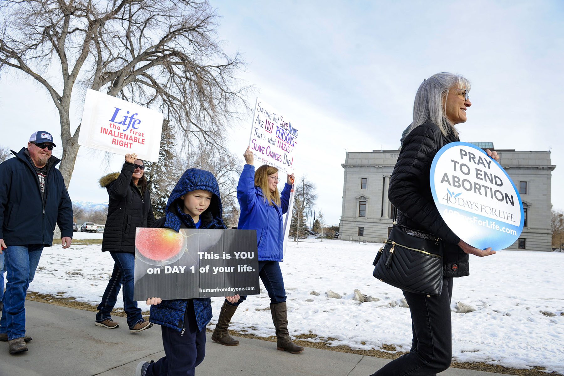 Anti-abortion activists holding signs gather at the Montana State Capitol for the March for Life.