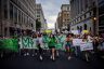 A large group of young abortion rights activists hold signs and banners as they march.