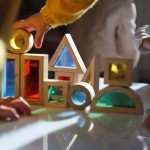 Small children play with colorful wooden building blocks on the table.