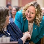 Emma Greenman greets a colleague at the Minnesota State Capitol.