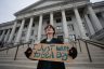 A protester holds a sign that reads 