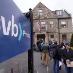 Customers and bystanders form a line outside a Silicon Valley Bank branch location.