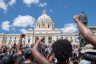 Supporters raise their fists while standing at the State Capitol during a National Mother's March.