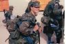 Photo of Christina Schauer and fellow soldiers dressed in uniform line up to receive equipment at Camp Virginia in Kuwait.