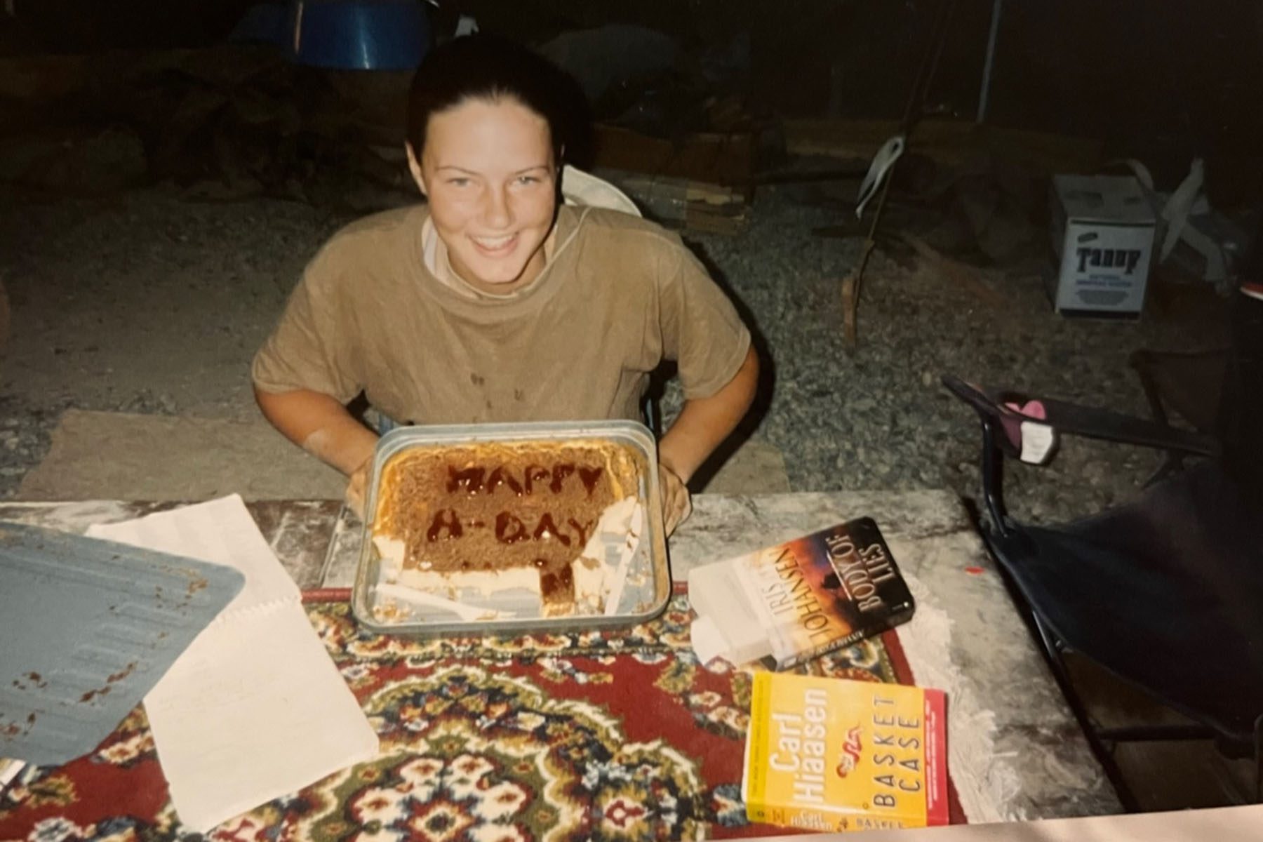 Christina Schauer holds a pan with a cake in it that reads Happy B-day