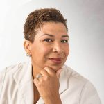 Portrait of Michel Martin holding her chin and smiling faintly.