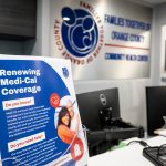 A front desk at a community health center with a sign about Medi-Cal medical coverage.