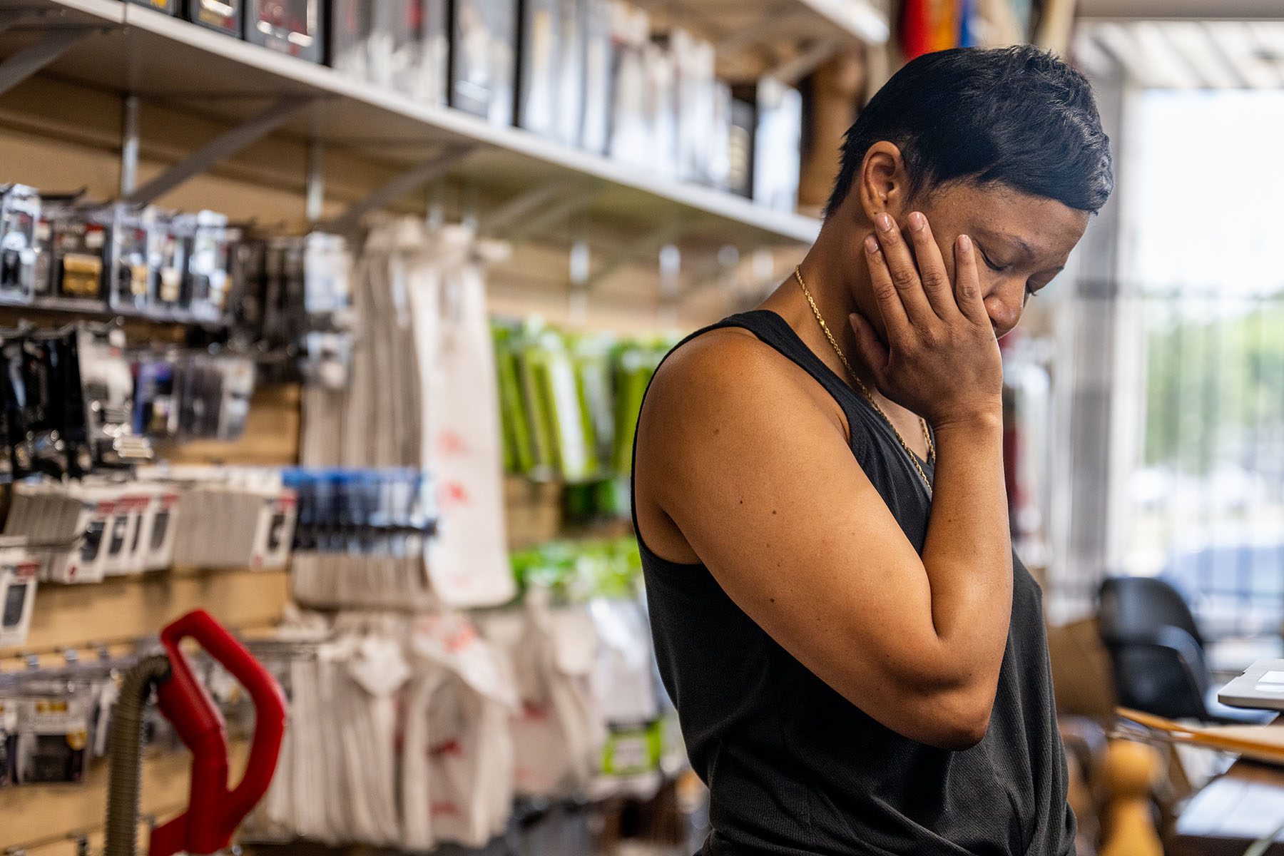 Business owner Lynn Gooden looks tired and frustrated as she takes a pause during work at her business, Mother's Hair Beauty Supply.