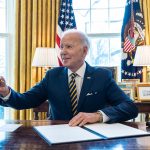 President Biden signs an Executive Order in the Oval Office of the White House.