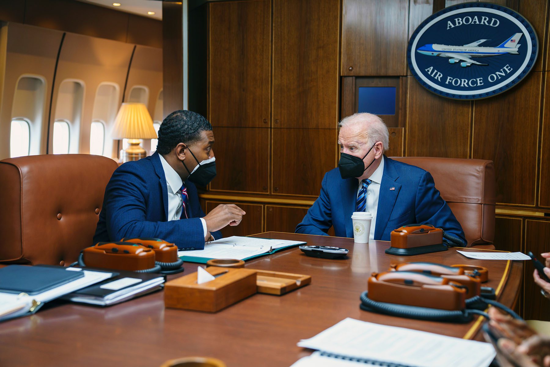 President Biden talks with EPA Administrator Michael Regan aboard Air Force One.