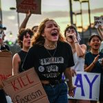 LGBTQ+ rights supporters protest against Florida Gov. Ron DeSantis outside a campaign event.