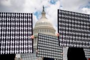 Demonstrators hold up placards representing the number of the people who have died due to gun violence during an event with gun violence prevention advocates on Capitol Hill.