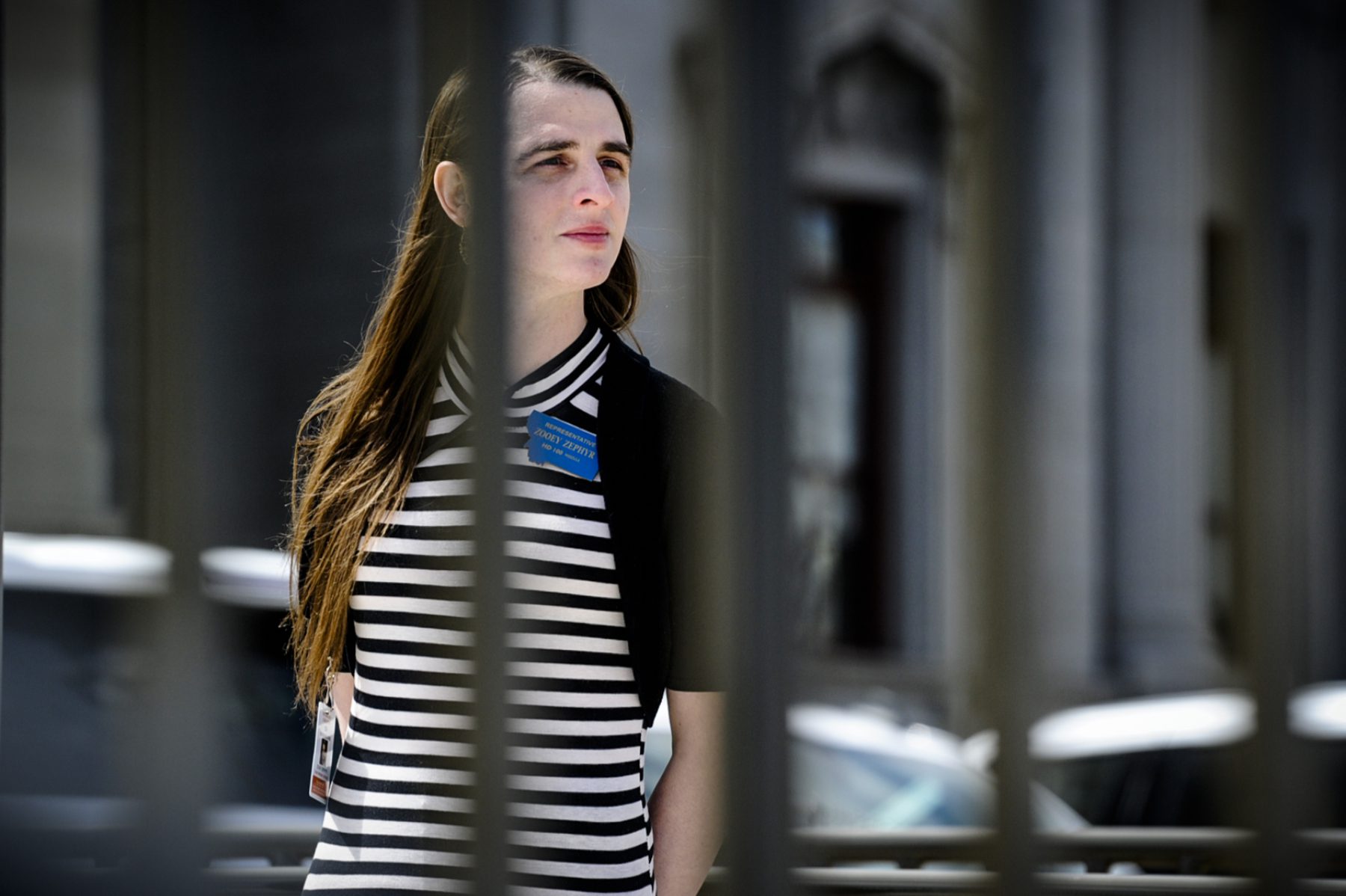 Transwoman Rep. Zooey Zephyr pictured behind fence on the steps of the Montana State Capitol during ally.