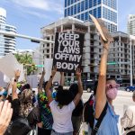 A person in a crowd holds a sign in support of abortion access.