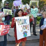 Grace Meng holds a sign that says thank you while surrounded by smiling people